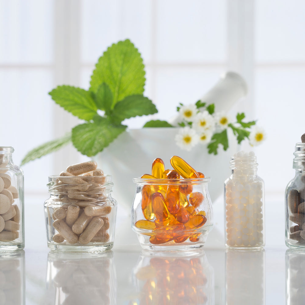 Five glass jars full of prebiotic and probiotic supplements
