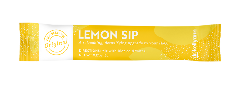 Citrus, berries, greens, and water arranged on a bright wellness-inspired surface