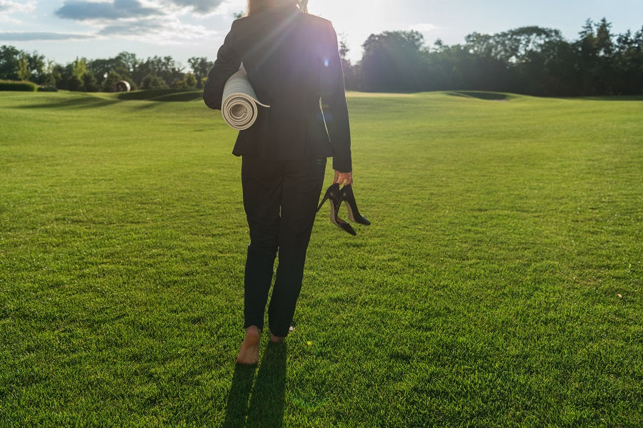 Woman walking barefoot across a field