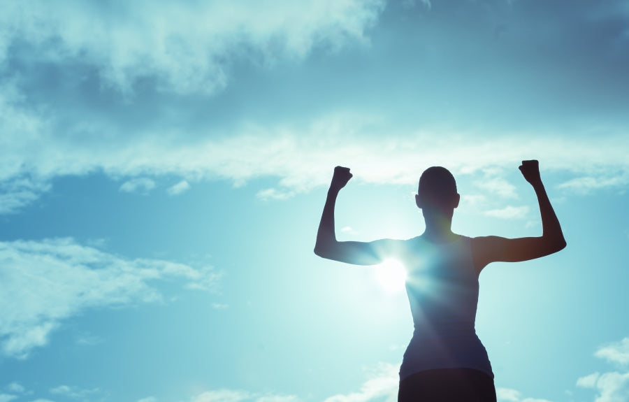 Silhouette flexing their arms and building a healthy mindset against the sun