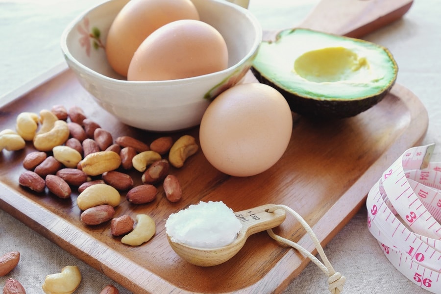 Eggs, nuts, and avocado on a wood tray