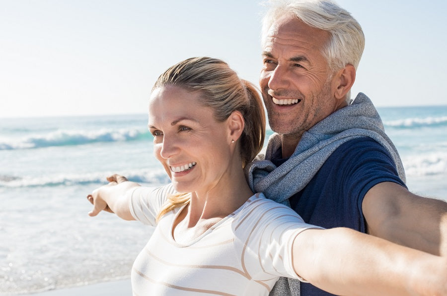 Man and woman doing yoga on the beach