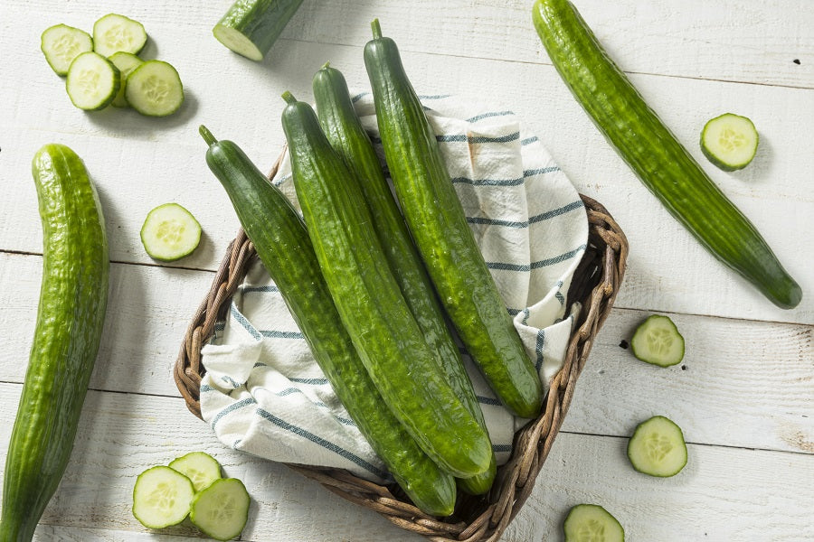 Basket of cucumbers packed with health beenfits on a white table