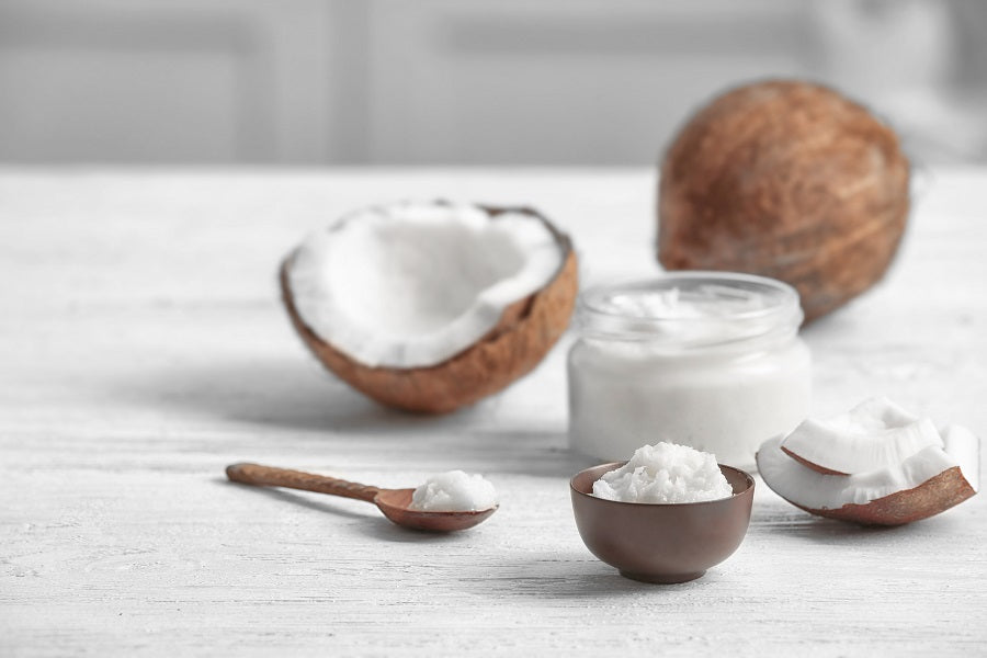 A full coconut and half a coconut on a white counter