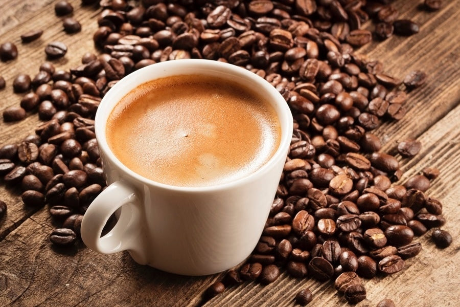 Coffee mug surrounded by coffee beans