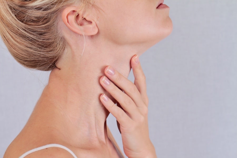 A woman touching her throat