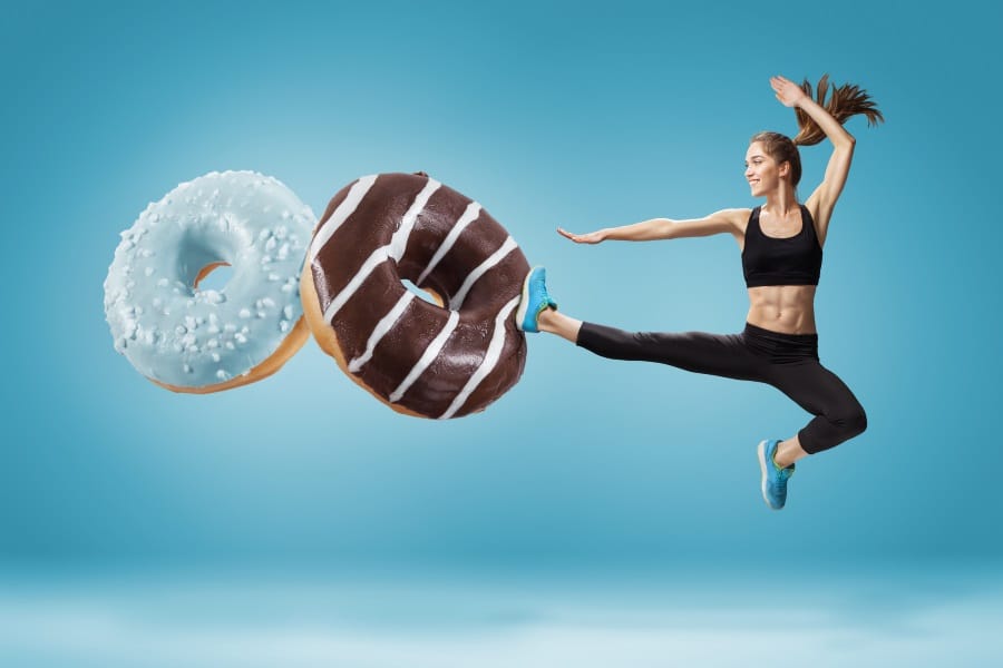 A woman karate kicking donuts