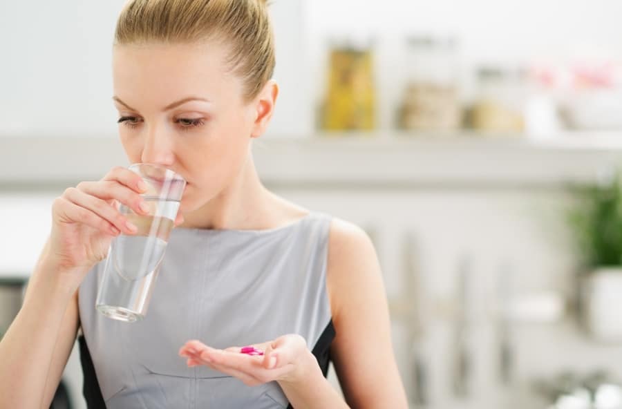 A woman taking the best supplements to boost her immune system
