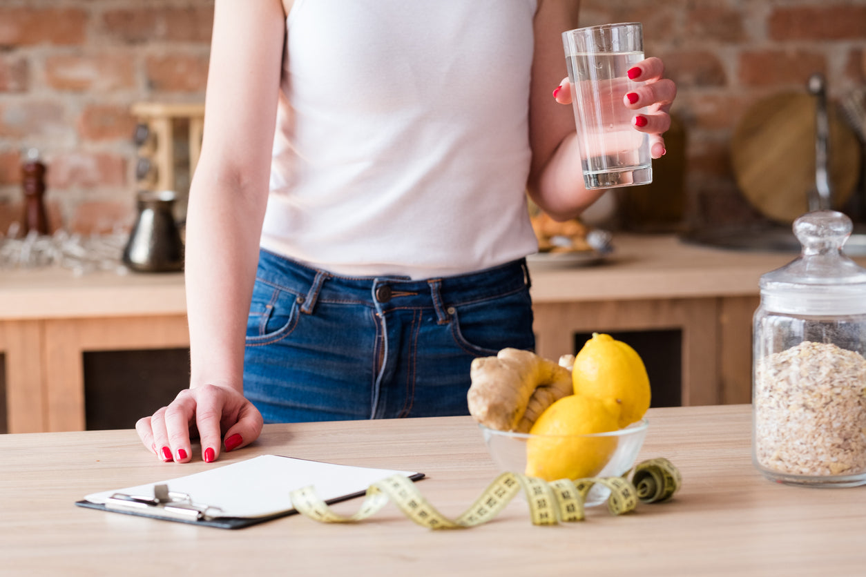 woman drinking water and making diet plans