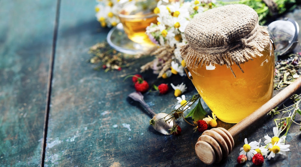 Jar of paleo sweetener honey surrounded by flowers