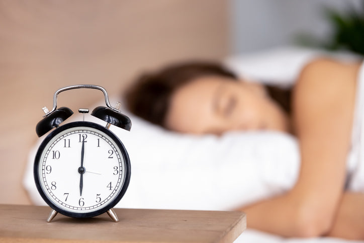 clock in front of woman sleeping