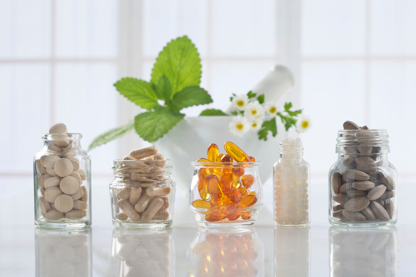 Five glass jars full of prebiotic and probiotic supplements
