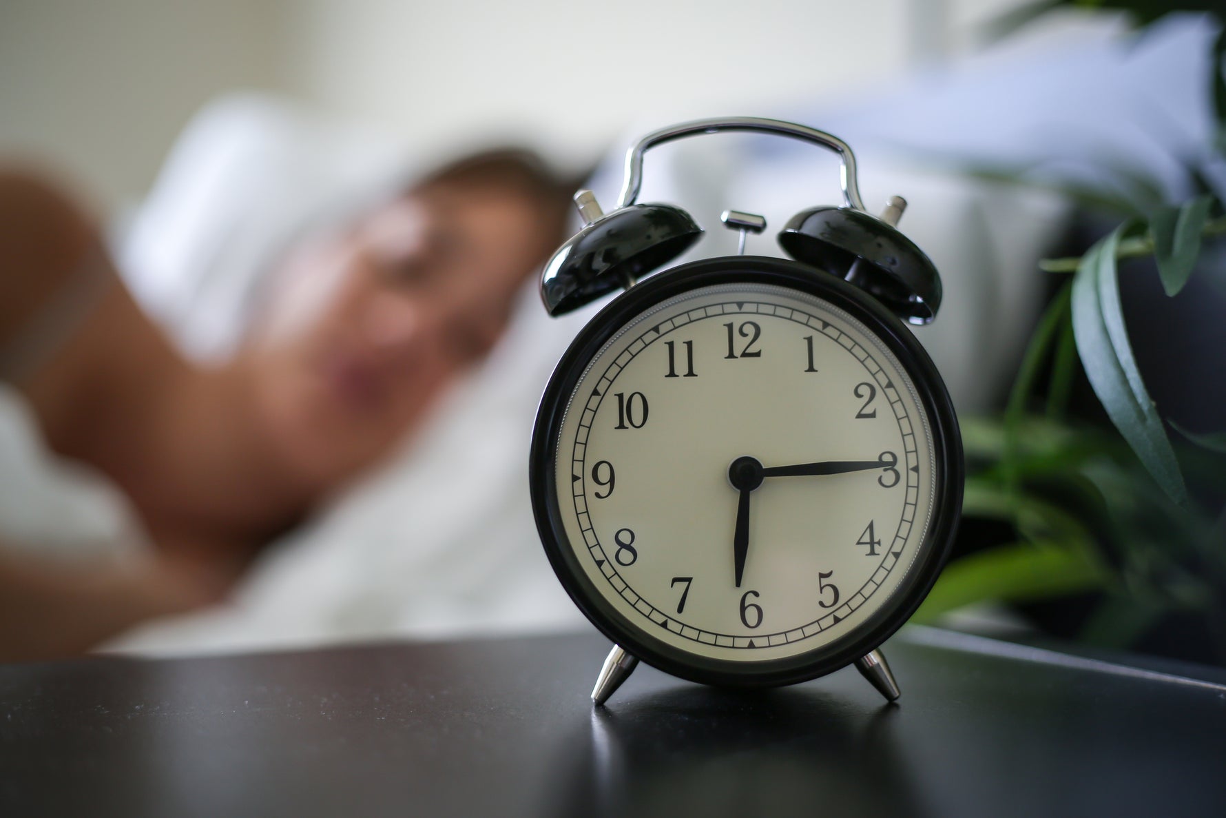 Alarm clock next to sleeping woman
