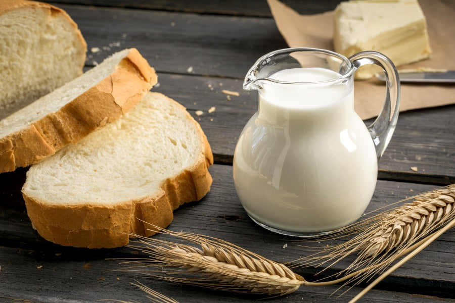 Bread and milk sitting on a table