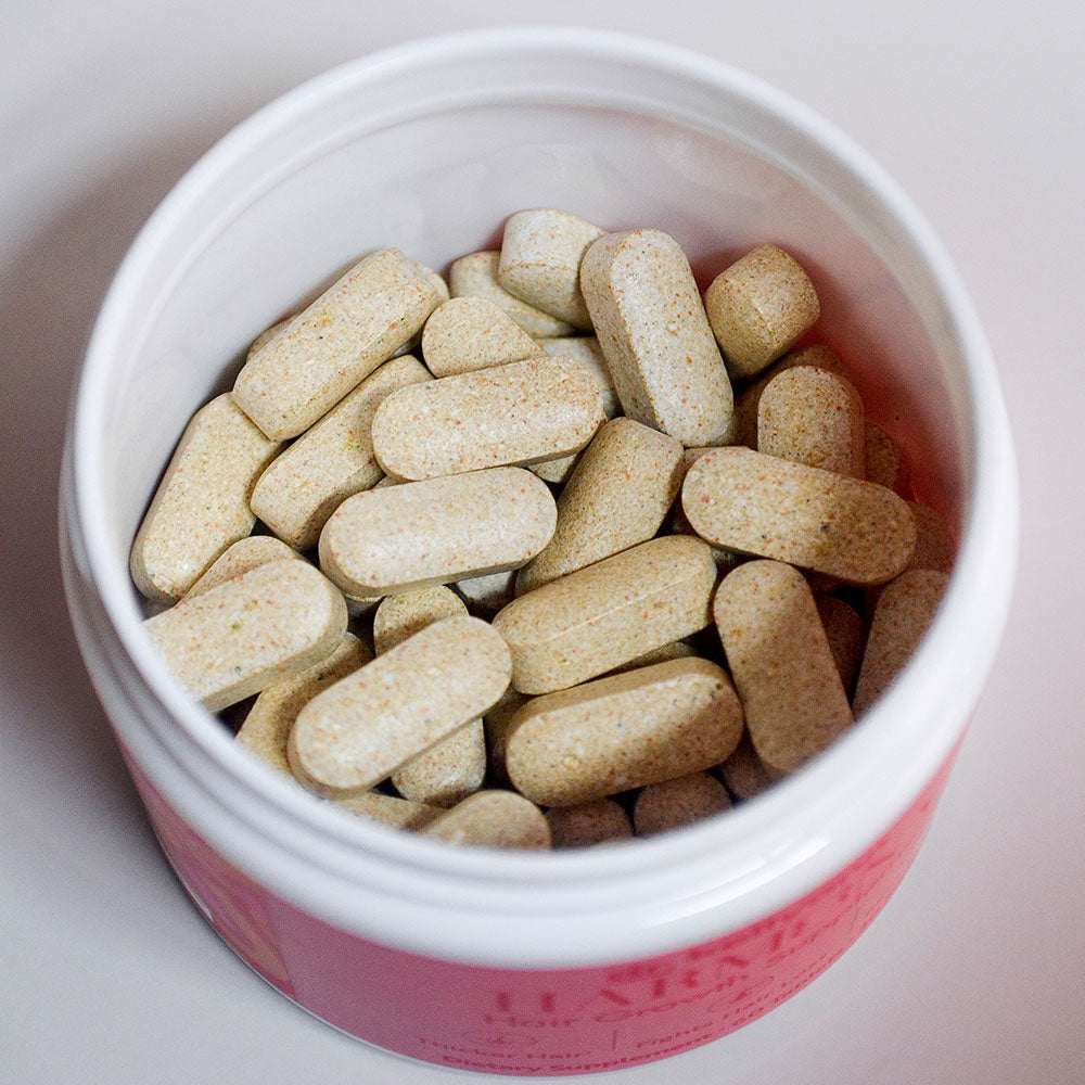Jar of beige cylindrical pills - Harmony Hair Growth