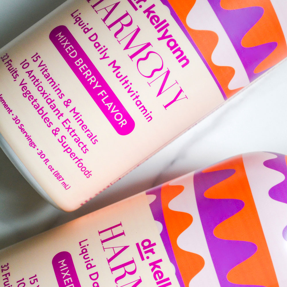 Two bottles of Dr. Kellyann Harmony Liquid Daily Multivitamin with colorful labels on a white background.