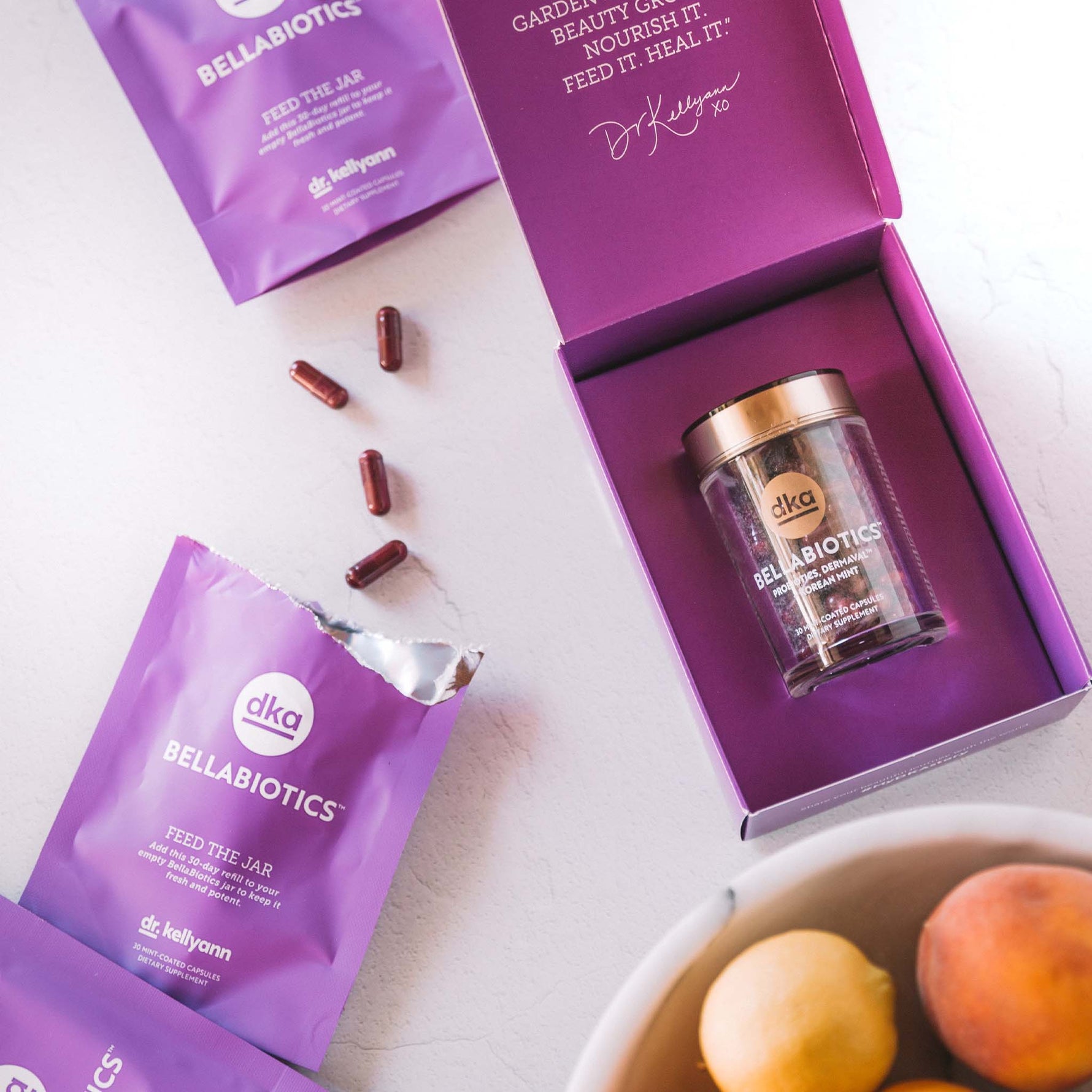 Purple packet of DKA Bellabiotics supplement and Bellabiotics jar on a white background