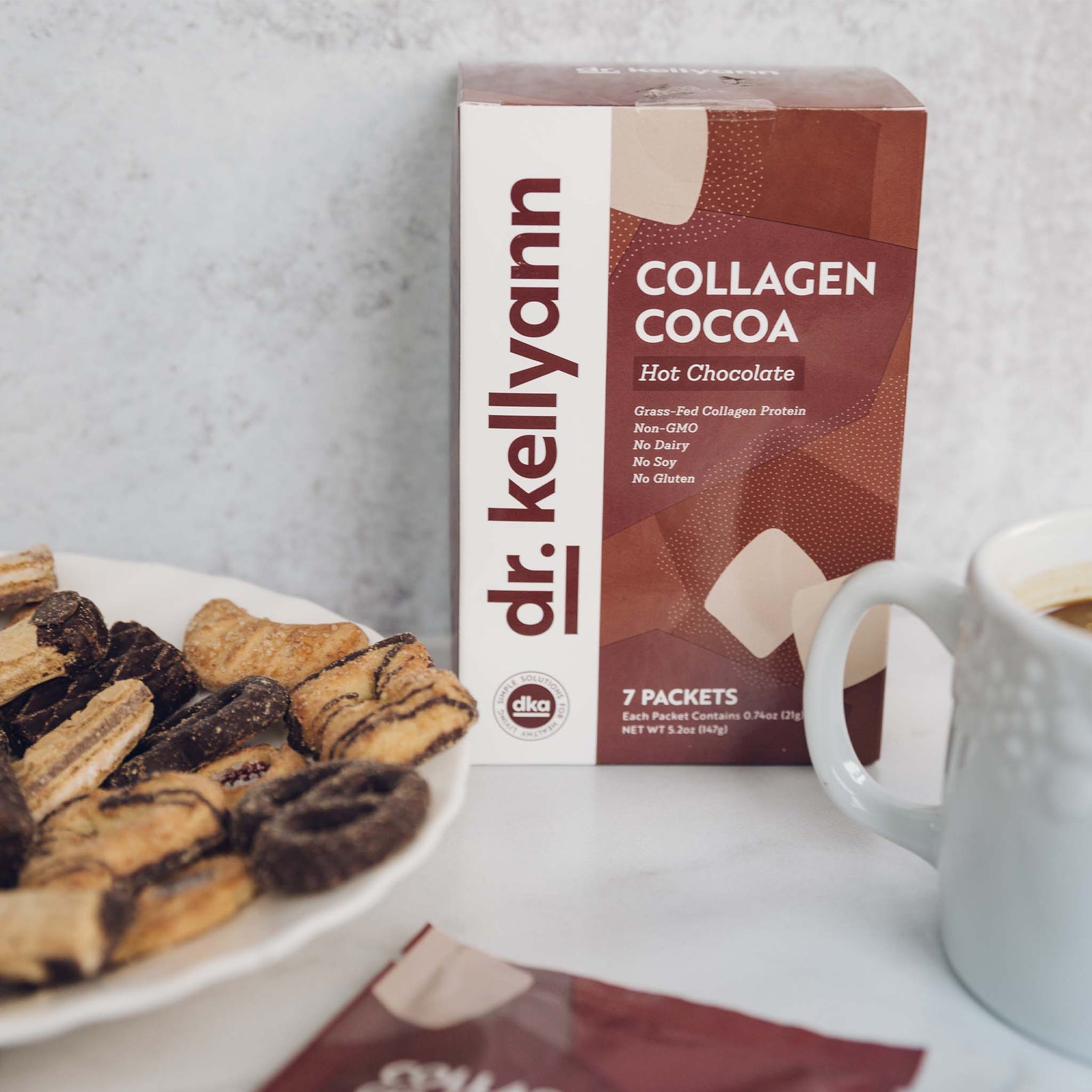 Collagen Hot Cocoa Package next to a plate of biscuits 
